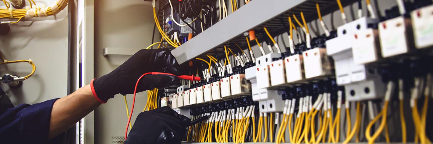 électricien devant un tableau électrique en industrie